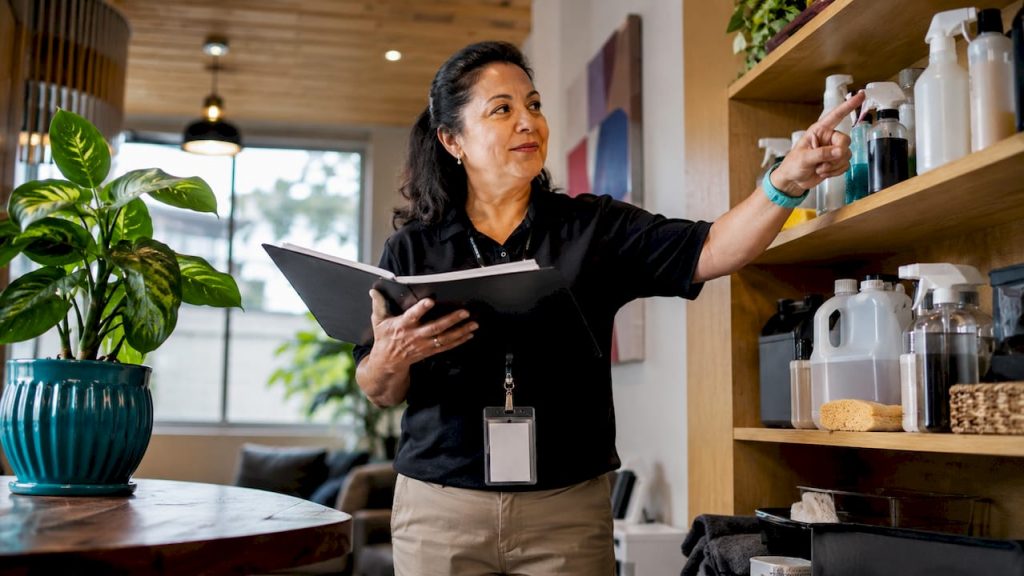 Supervisor reviewing eco-friendly cleaning products in office lobby