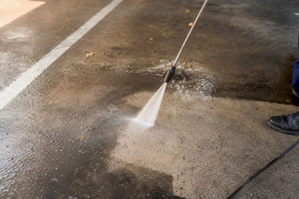 Pressure washer cleaning parking lot asphalt