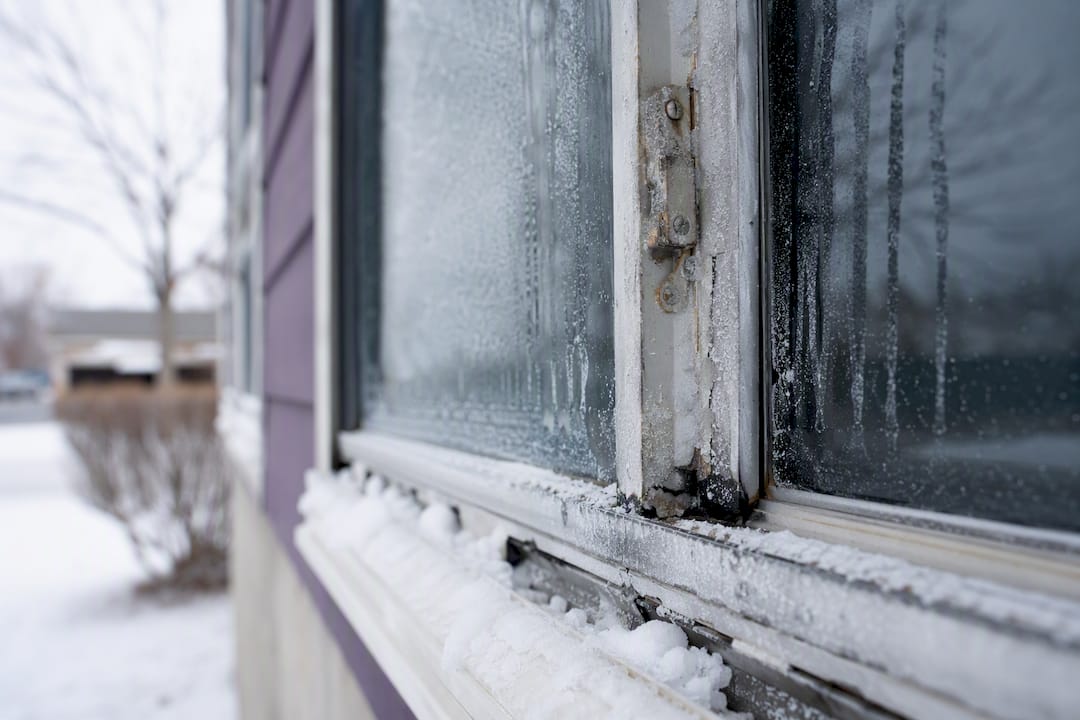 Frosty window with salt residue on frame and hardware