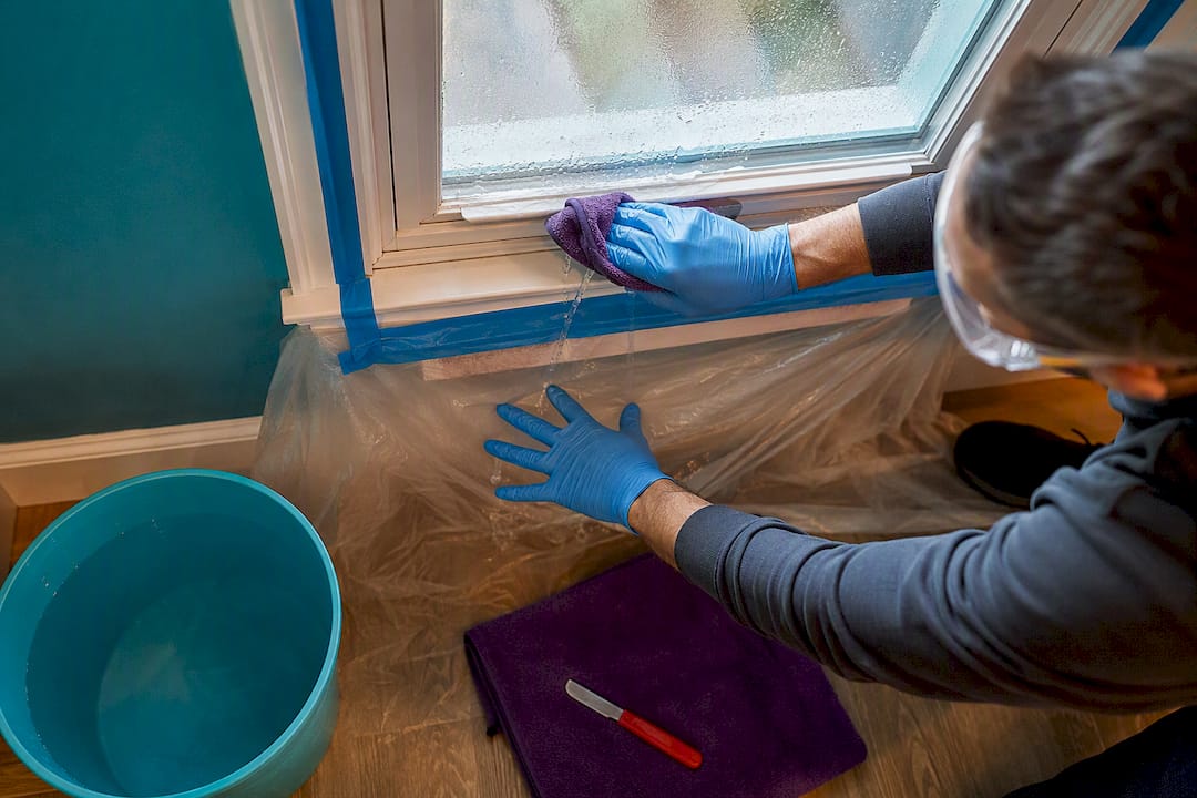 Preparing window with tape and protective sheeting