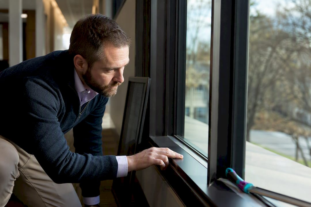 Representative inspecting cleaned office window