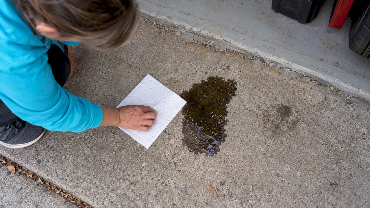 Fresh oil drip on concrete driveway