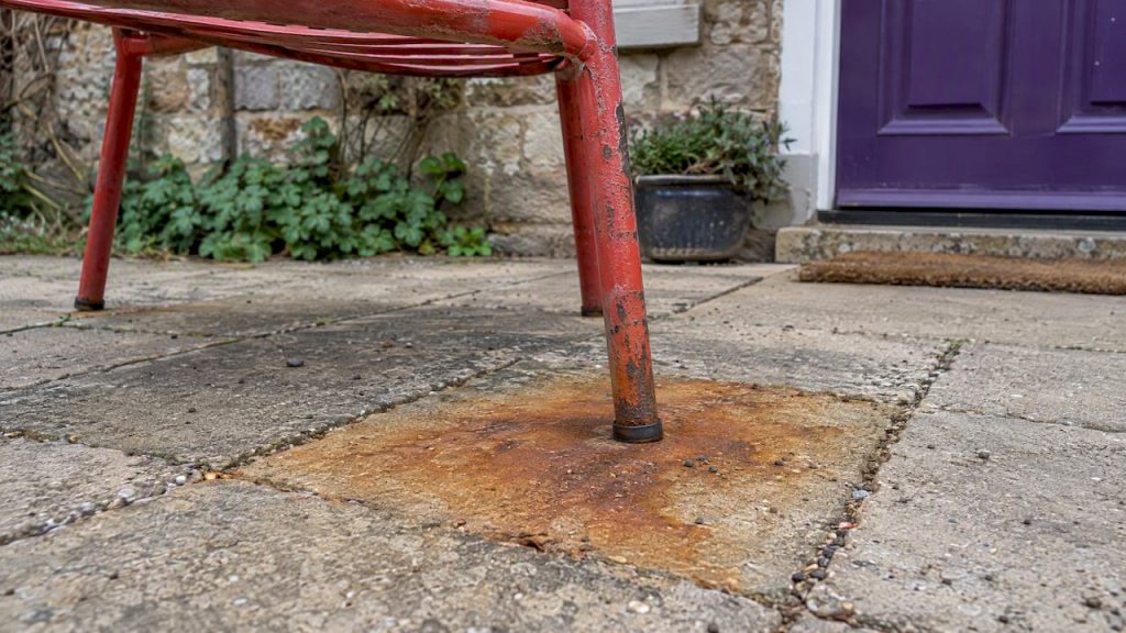 Rust stain beneath a red metal chair